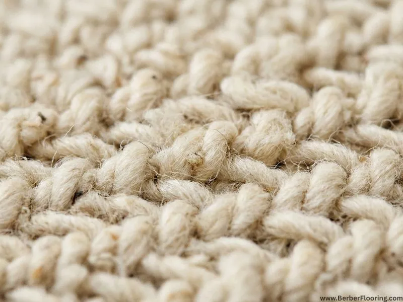 A macro close-up showing the detail of natural wool Berber carpet loop construction texture.